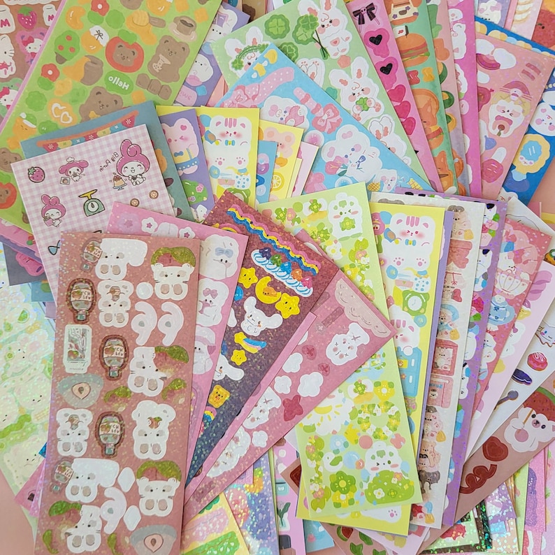 May include: A collection of colorful sticker sheets featuring cute animal illustrations, including bunnies, bears, and other whimsical characters. The stickers are perfect for adding a touch of personality to journals, planners, laptops, and other items.