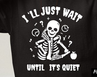 May include: Black sweatshirt with a white graphic of a skeleton holding an apple and clocks. The text on the sweatshirt reads "I'll just wait until it's quiet".
