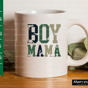 Pu&ograve; includere: Una tazza in ceramica bianca con un motivo mimetico verde, blu e grigio. Il testo "BOY MAMA" &egrave; stampato sulla tazza in un carattere audace e robusto.