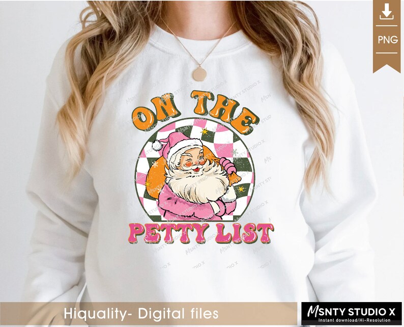 May include: A white sweatshirt with a pink and orange graphic design featuring Santa Claus with a bag of gifts. The graphic says "On the Petty List".