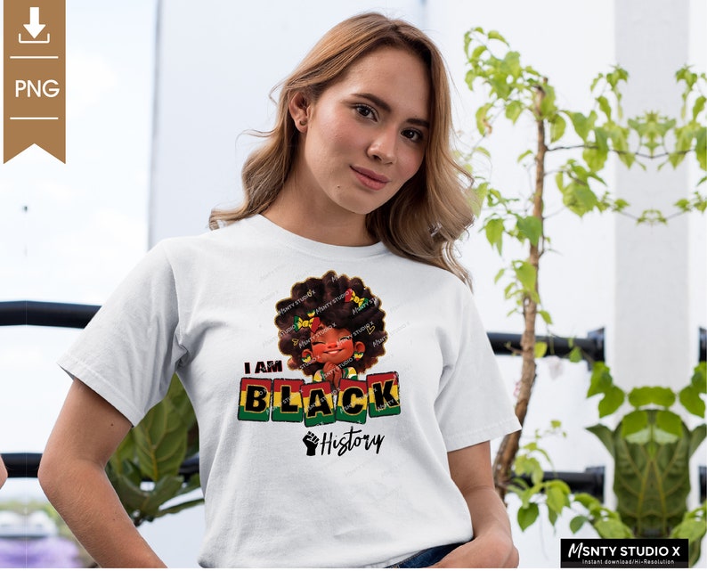 K&ouml;nnte beinhalten: Ein wei&szlig;es T-Shirt mit einem Grafikdesign, das ein Cartoon-M&auml;dchen mit Afro-Frisur zeigt. Das Design enth&auml;lt die Worte "I am Black History" und eine geballte Faust.