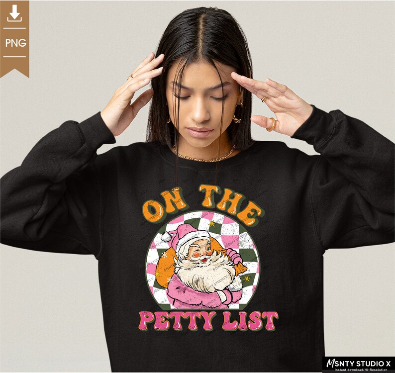 May include: Black sweatshirt with a pink and green graphic of Santa Claus with the text "On the Petty List".