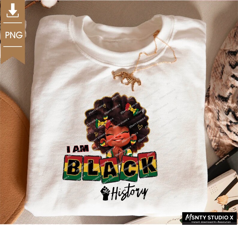 K&ouml;nnte beinhalten: Ein wei&szlig;es T-Shirt mit einem Grafikdesign, das ein Cartoon-M&auml;dchen mit brauner Haut und lockigem Haar zeigt. Das M&auml;dchen tr&auml;gt ein rot-gelb-gr&uuml;nes Stirnband und h&auml;lt ihre H&auml;nde in einer Gebetsposition zusammen. Der Text "I AM BLACK History" ist in rot-gelb-gr&uuml;nen Buchstaben unter dem M&auml;dchen gedruckt.