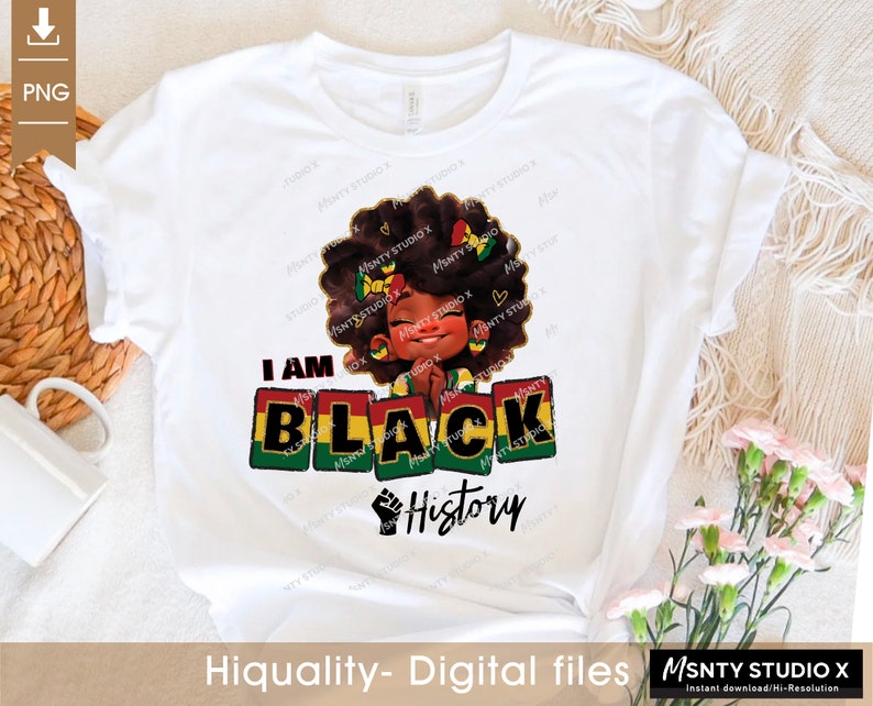 K&ouml;nnte beinhalten: Ein wei&szlig;es T-Shirt mit einem Grafikdesign einer schwarzen Comicfigur mit Afrofrisur, die ein gelbes, gr&uuml;nes und rotes Stirnband tr&auml;gt. Der Text "I AM BLACK History" ist in gr&uuml;nen, gelben und roten Buchstaben mit einer erhobenen schwarzen Faust gedruckt.
