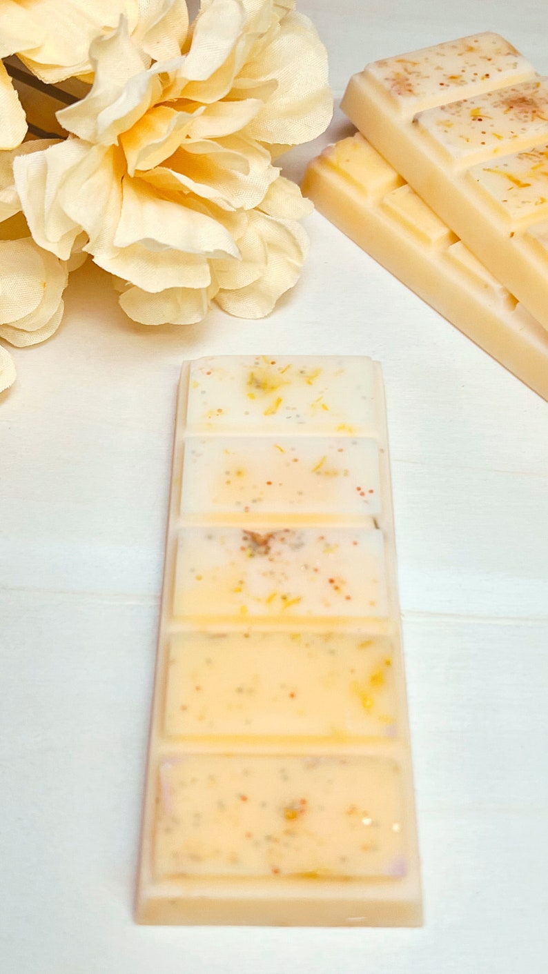 Puede incluir: Un juego de cinco fundidos de cera en forma rectangular. Los fundidos de cera son de color amarillo claro con motas de purpurina dorada. Los fundidos de cera est&aacute;n apilados.