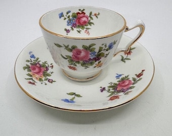Può includere: Servizio da tè bianco con un motivo floreale di rose rosa, blu e gialle. La tazza e il piattino hanno bordi dorati. La tazza da tè ha un diametro di 7,6 cm e un'altezza di 6,4 cm.