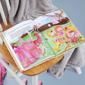 Pode incluir: Um livro infantil aberto com ilustra&ccedil;&otilde;es coloridas de animais e uma paisagem fant&aacute;stica. O livro inclui texto como "Jambo the Jellyphant" e "Caddy the Catfish".
