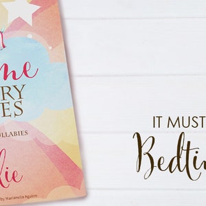 May include: A personalised book titled "Bedtime Nursery Rhymes" with a watercolour background and the name "Charlie" printed on the cover. The book is open to reveal colourful illustrations and the text "Songs, Poems & Lullabies for Charlie".