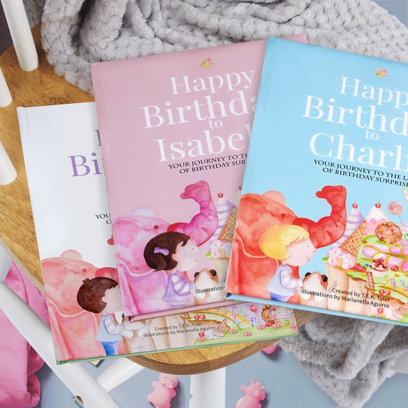Pode incluir: Dois livros infantis personalizados, rosa e azul, com as palavras "Feliz anivers&aacute;rio para" e os nomes "Isabel" e "Charlie". Os livros apresentam ilustra&ccedil;&otilde;es de elefantes e doces.