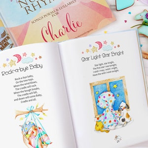 May include: A children's book with a blue and white cover featuring the title "Songs Poems & Lullabies for Charlie" and illustrations of stars and a moon. The book is open to two pages, one with the poem "Rock-a-bye Baby" and the other with the poem "Star Light Star Bright".