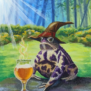 Op de afbeelding: Een paarse en bruine pad met een bruine en rode tovenaarshoed zit op een rots met een glas bier ervoor. De pad bevindt zich in een bosrijke omgeving met groen gras en bomen op de achtergrond.