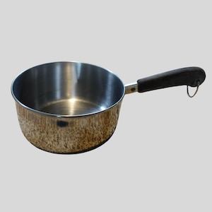 May include: A stainless steel saucepan with a dark brown handle and a small metal loop. The pan has a shiny, reflective surface and is designed for cooking. The handle is attached with a metal bracket.