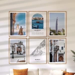 Può includere: Sei stampe artistiche incorniciate con scene di Rabat, Marocco. Le stampe includono immagini di architettura, paesaggi urbani e una mappa. Ogni stampa è in una cornice di legno ed è esposta su una parete bianca. Tema di viaggio.