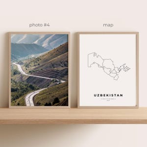 May include: Two framed prints on a wooden shelf. One print is a photograph of a winding road through a mountain range. The other print is a minimalist map of Uzbekistan with the country's name and coordinates.