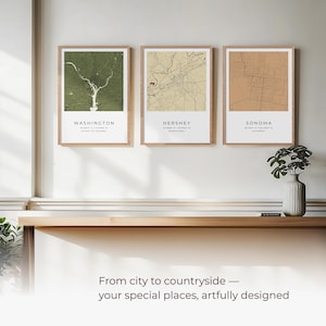 May include: Three framed city maps with a light brown wood frame. The maps are of Washington, Hershey, and Sonoma. The maps are printed on a white background with brown lines for the streets. The maps are hanging on a white wall above a wooden shelf.