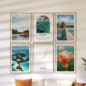 May include: Six framed art prints depicting scenes from Palau. The prints show boats on the water, underwater scenes with fish, a wooden pier, aerial views of islands, a map, and jellyfish.