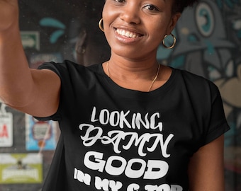 May include: A black cropped t-shirt with white text that reads "Looking Damn Good In My C Top".