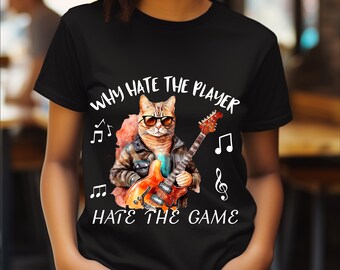May include: Black t-shirt with a white graphic of a cat playing a guitar. The text on the shirt reads "Why hate the player hate the game".