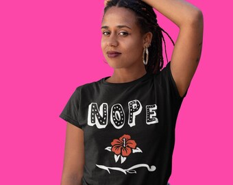 May include: A black t-shirt with the word "NOPE" in white outlined in black dots. A red hibiscus flower with a black stem is below the word.