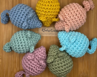May include: A set of seven crocheted cat toys in various colors, including blue, green, pink, yellow, and brown. The toys are shaped like fish and have a playful, whimsical design.  The text on the tag reads "Klairs Krafts Bespoke Handmade Gifts for you and your cat."