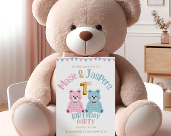 Könnte beinhalten: Eine weiße Karte mit einem rosa und blauen Teddybär-Motiv. Die Karte lautet "You're invited to Masie & Jaspers 1st Birthday Party" mit Datum und Uhrzeit der Party sowie der Adresse. Die Karte wird von einem großen, beigen Teddybären gehalten.