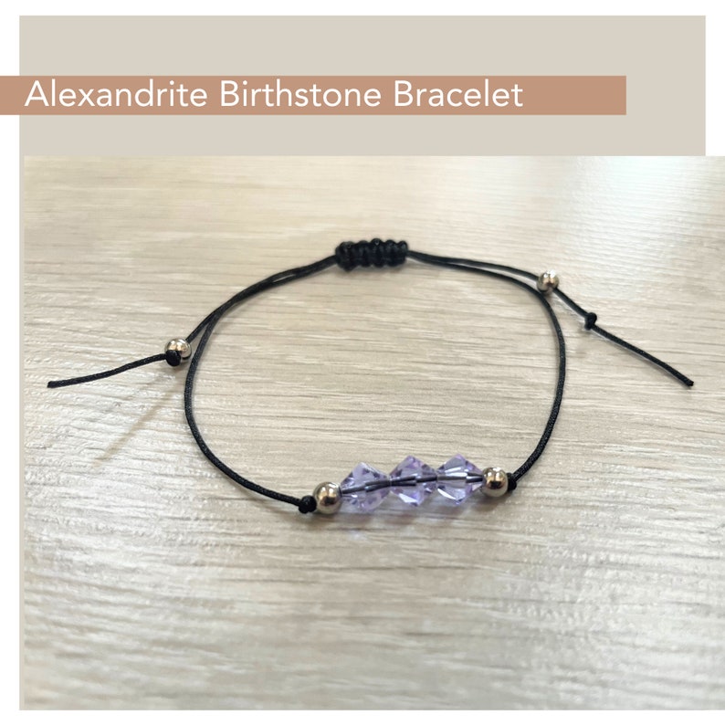 May include: A black adjustable string bracelet with a silver clasp and three purple faceted beads. Alexandrite Birthstone Bracelet.