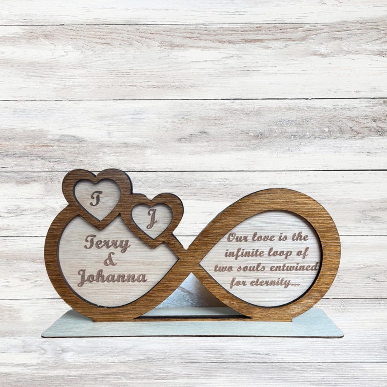 Puede incluir: S&iacute;mbolo de infinito de madera con dos corazones, grabado con los nombres "Terry & Johanna" y la cita "Nuestro amor es el bucle infinito de dos almas entrelazadas por la eternidad..."