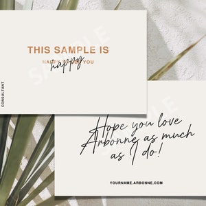 Puede incluir: Dos tarjetas blancas con texto. La tarjeta superior dice "This sample is happy you happy" en texto marrón. La tarjeta inferior dice "Hope you love Arbonne as much as I do!" en texto cursivo negro. La tarjeta inferior también tiene el texto "YOURNAME.ARBONNE.COM" en texto negro.