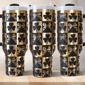 May include: Three gold stainless steel tumblers with black and gold checkered pattern and shamrock and bow designs.