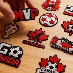 May include: Embroidered patches with a soccer theme. Designs include a soccer ball, a maple leaf with a soccer player, and the text "MVP" and "Canada". The patches are red, white, and black.
