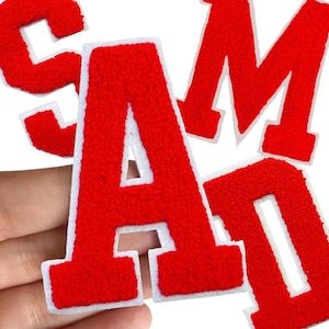 May include: Red embroidered fabric letters spelling out the word "SAMD" with white borders. The letters are displayed against a white background. The brand name "Longancraft" is at the top of the image.