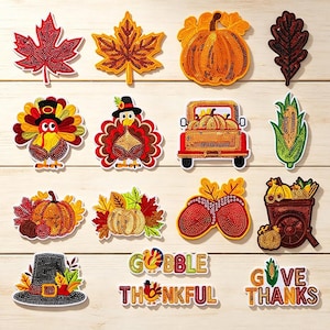 May include: A collection of fourteen embroidered patches featuring autumn themes including maple leaves, pumpkins, turkeys, a truck, corn, a wheelbarrow, a pilgrim hat, and text reading GOBBLE, THANKFUL, and GIVE THANKS, all with beaded textures.