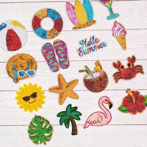 May include: A collection of colorful, beaded patches with a summer theme. Designs include a beach ball, life preserver, surfboards, cocktail, ice cream cone, flip-flops, sun hat, starfish, coconut drink, crab, sun, palm tree, flamingo, leaf, and hibiscus flower. The text "Hello Summer" is also included.
