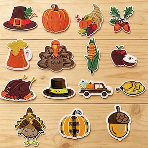 May include: A collection of fourteen embroidered patches featuring Thanksgiving and autumn themes, including a pilgrim hat, pumpkins, a cornucopia, acorns, a turkey, a corn cob, an apple, a roasted turkey, a truck, and a beer mug, labelled Longancraft.