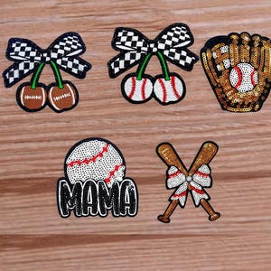 May include: Collection of baseball-themed patches. Includes a baseball glove, baseballs, crossed bats, and cherries with checkered bows. The patch that says "MAMA" is also included. The patches are embellished with sequins and embroidery.