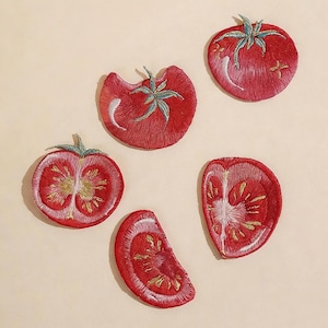 May include: Embroidered tomato patches in various stages of slicing, with green stems and detailed stitching. The patches are red with yellow and white accents. The text "Longancraft" is at the top of the image.