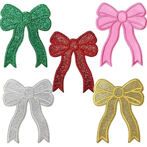 Peut inclure: Cinq appliqués en forme de nœuds brillants, verts, rouges, roses, argentés et dorés. Chaque nœud a un contour cousu et une texture scintillante. Le texte "Longancraft" est en haut de l'image.