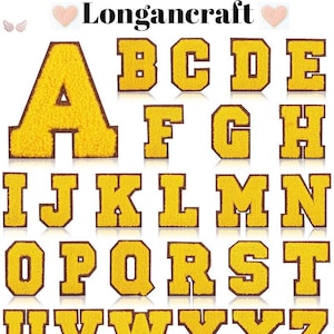 Op de afbeelding: Een set van 26 gele viltletters met bruine contouren, die het Engelse alfabet voorstellen. De letters zijn alfabetisch gerangschikt, beginnend met A en eindigend met Z.