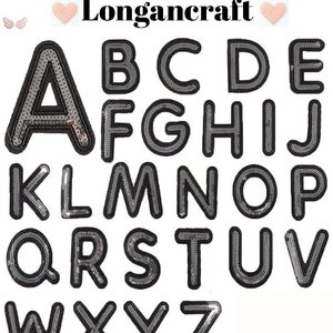May include: A set of 26 iron-on alphabet letters with a black outline and silver sequins. The letters are uppercase and are arranged in alphabetical order.