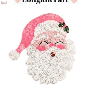 Peut inclure: Un écusson de Père Noël à paillettes avec un bonnet rose et des joues roses. Le Père Noël a une barbe blanche et une expression souriante. Le texte "Longancraft" est au-dessus du Père Noël.