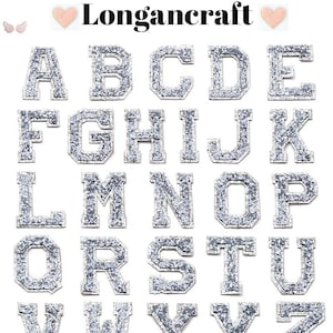 May include: A set of 26 silver glitter iron-on letters, A through Z, in a varsity style font.  The letters are perfect for adding a personalised touch to clothing, bags, and other fabric items.
