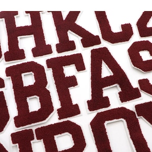 May include: A set of burgundy felt letters with white outlines. The letters are in uppercase and include the letters H, K, L, B, F, A, and D.