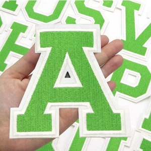 May include: A green embroidered letter "A" patch with a white border is held in a hand. The patch is part of a set of letter patches. The brand name "Longancraft" is at the top of the image.