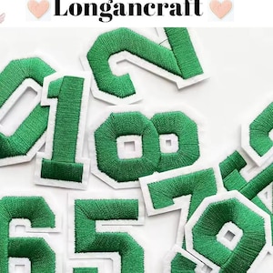 May include: Green felt iron-on numbers 0, 1, 2, 5, 6, 7, 8, and 9 with white outlines.  These numbers are perfect for adding a personalized touch to clothing, bags, or other fabric items.