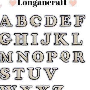 Może przedstawiać: Zestaw 26 termotransferowych liter alfabetu w kolorze kremowym z czarnym obramowaniem. Litery są wielkimi i ułożone są w kolejności alfabetycznej.