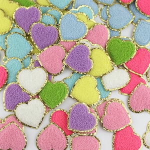 May include: Assortment of colorful fuzzy heart-shaped patches with gold glitter trim.