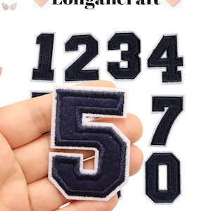 May include: Set of ten iron-on patches featuring the numbers 0 through 9 in a navy blue color with white outlines. The patches are designed in a classic varsity style font.