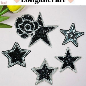 Peut inclure: Cinq patchs thermocollants avec des strass noirs et argentés. Un patch est une rose et les quatre autres sont des étoiles de différentes tailles.