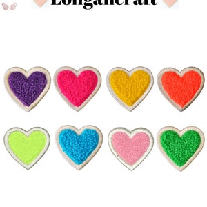 May include: Eight fuzzy heart-shaped patches in various colors, including purple, pink, yellow, orange, green, light green, blue, and light pink. The patches have a white outline and are arranged in two rows of four.