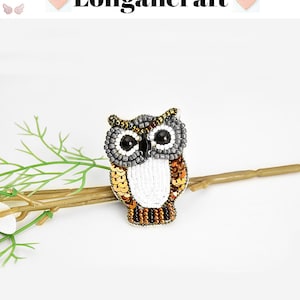 May include: A beaded owl brooch with brown, gold, white, and gray sequins. The owl has black eyes and a white body.